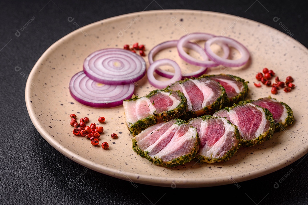 Deliciosas listras de bacon fresco com especiarias e sal sobre um fundo escuro de concreto