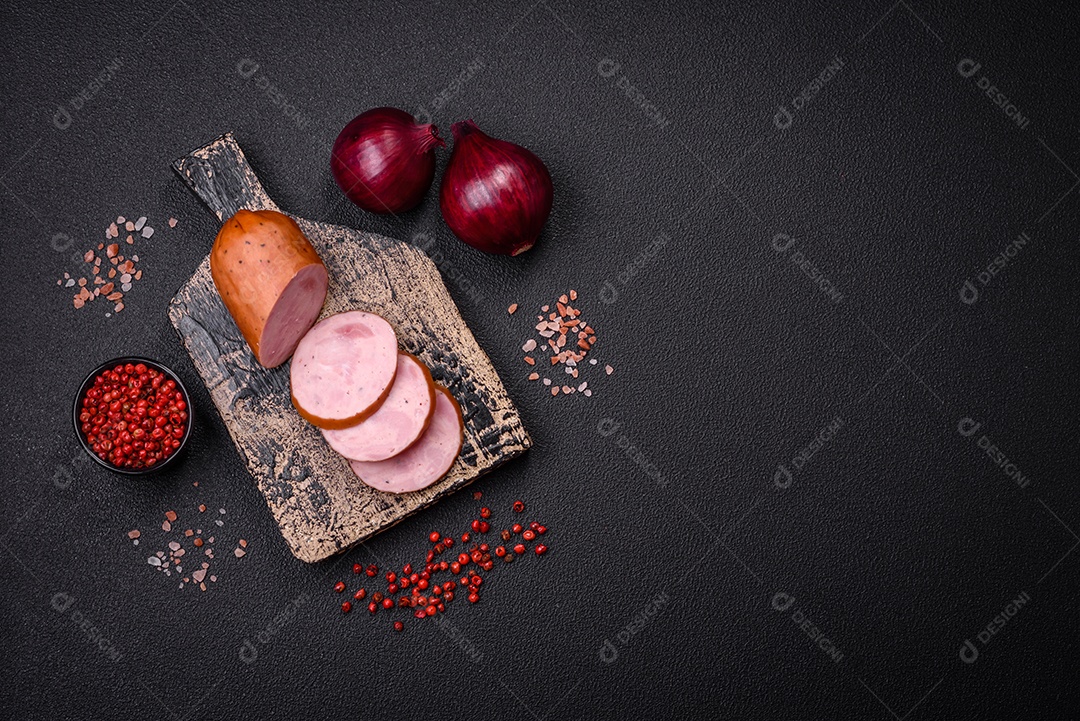 Deliciosa salsicha defumada com sal e especiarias cortadas em fatias sobre um fundo escuro de concreto