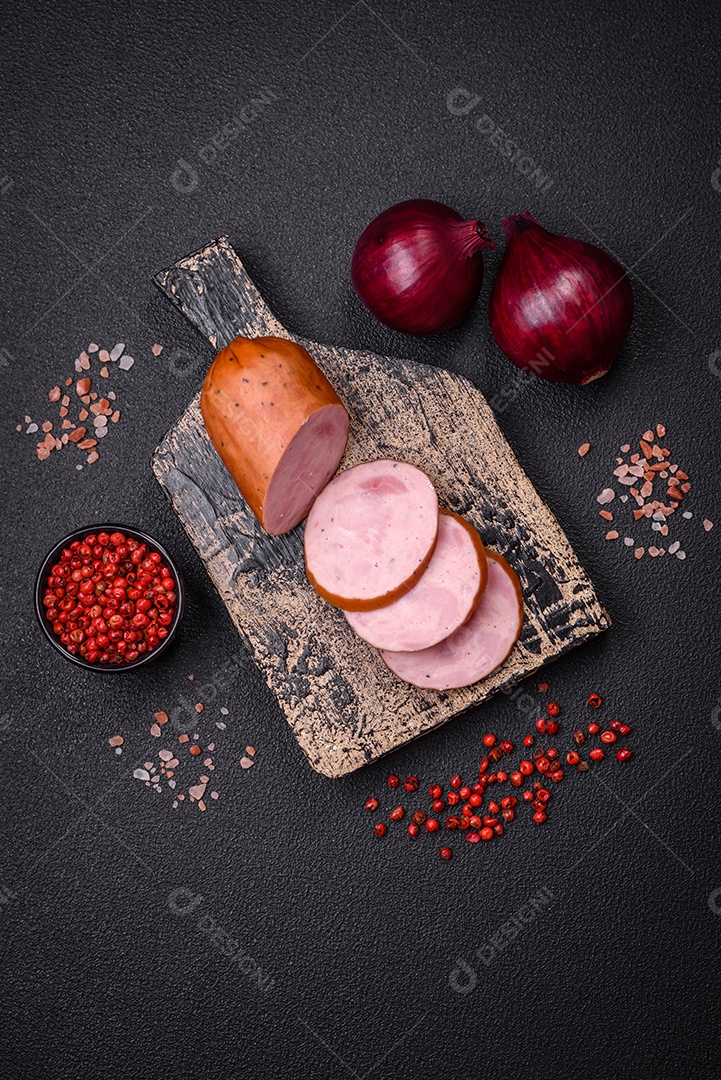 Deliciosa salsicha defumada com sal e especiarias cortadas em fatias sobre um fundo escuro de concreto