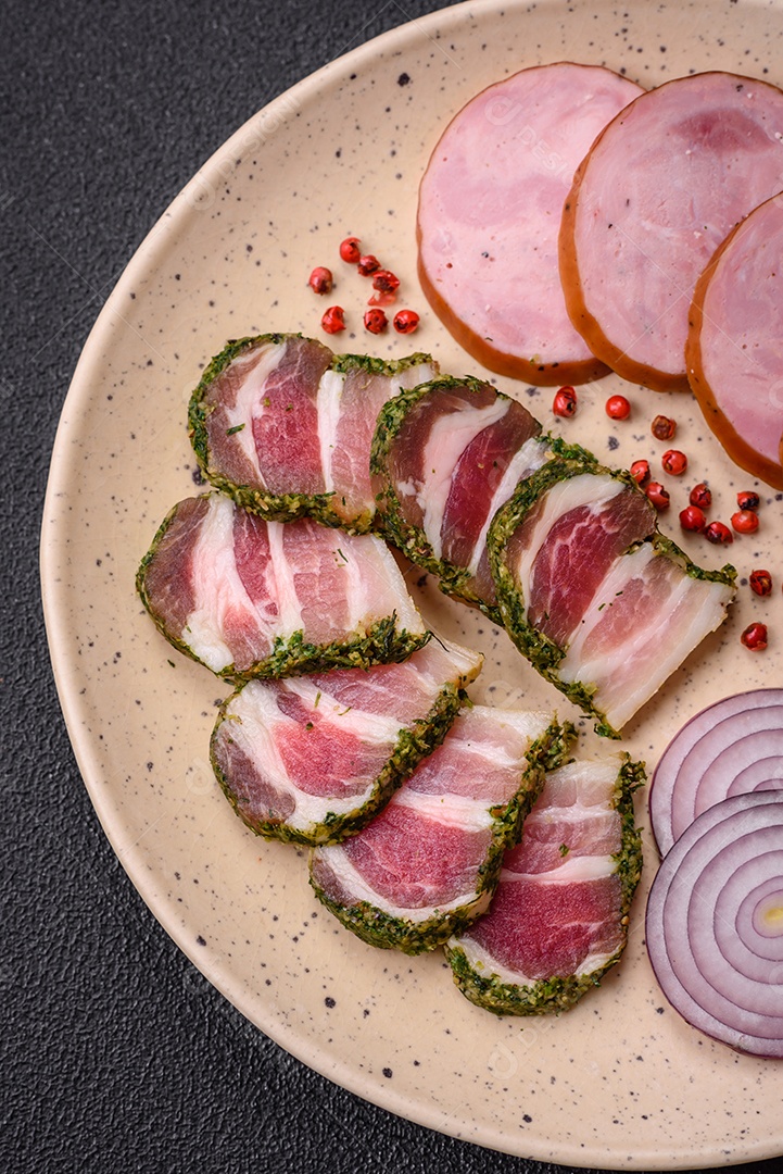 Deliciosa salsicha defumada com sal e especiarias cortadas em fatias sobre um fundo escuro de concreto