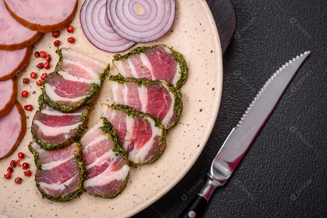 Deliciosa salsicha defumada com sal e especiarias cortadas em fatias sobre um fundo escuro de concreto