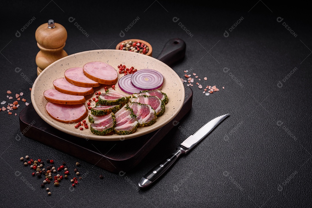 Deliciosa salsicha defumada com sal e especiarias cortadas em fatias sobre um fundo escuro de concreto