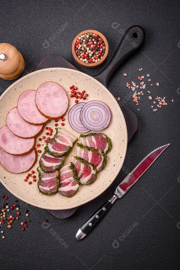 Deliciosa salsicha defumada com sal e especiarias cortadas em fatias sobre um fundo escuro de concreto