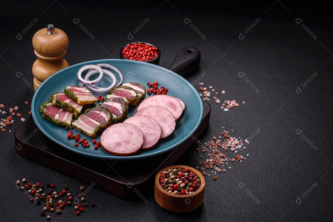 Deliciosa salsicha defumada com sal e especiarias cortadas em fatias sobre um fundo escuro de concreto