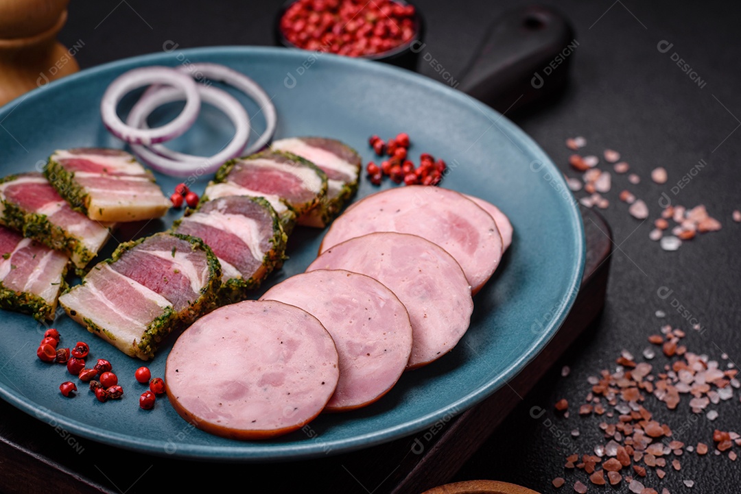Deliciosa salsicha defumada com sal e especiarias cortadas em fatias sobre um fundo escuro de concreto