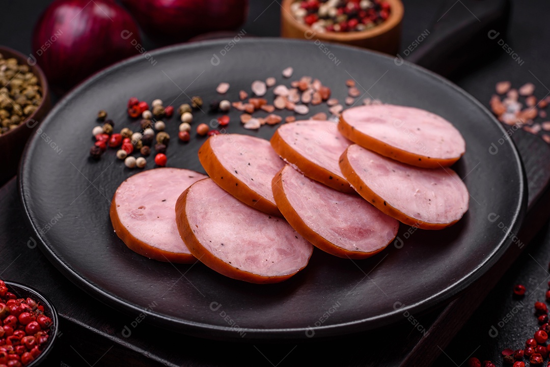 Deliciosa salsicha defumada com sal e especiarias cortadas em fatias sobre um fundo escuro de concreto