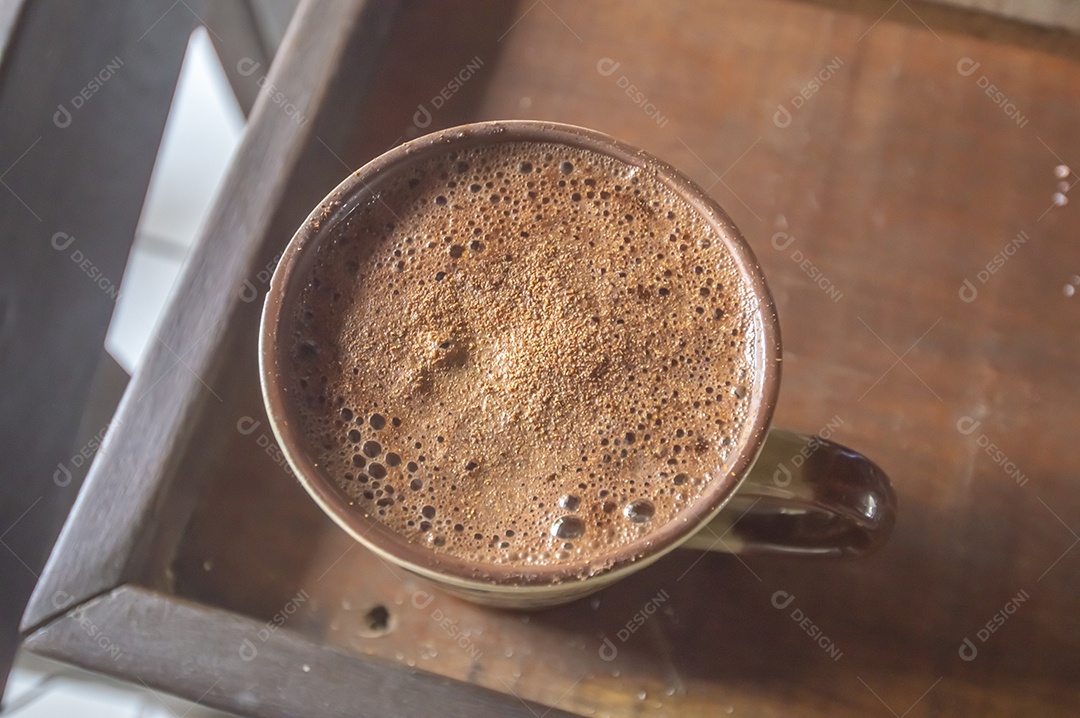 Grande xícara de café com cappuccino em uma mesa de madeira