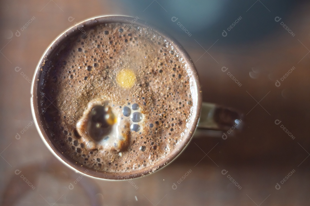 Grande xícara de café com cappuccino em uma mesa de madeira