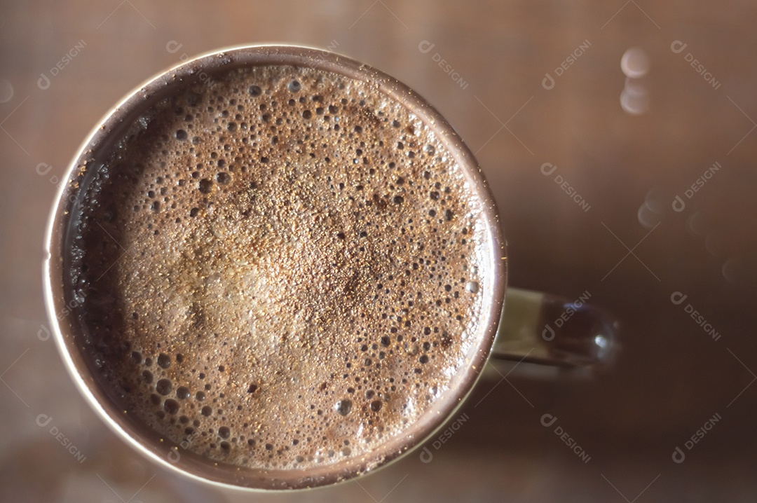 Grande xícara de café com cappuccino em uma mesa de madeira