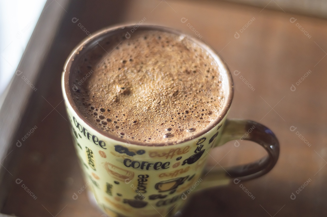 Grande xícara de café com cappuccino em uma mesa de madeira