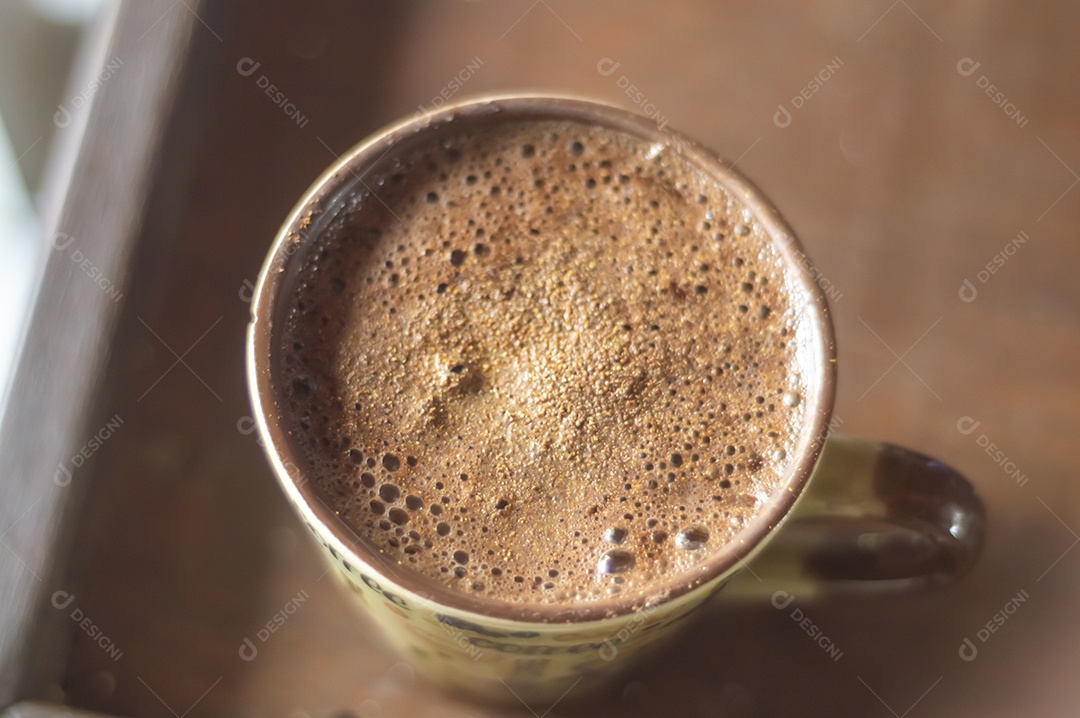 Grande xícara de café com cappuccino em uma mesa de madeira