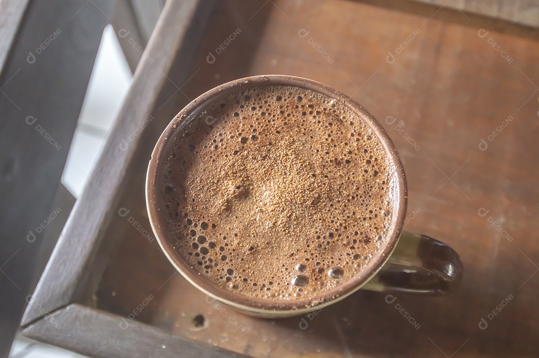 Grande xícara de café com cappuccino em uma mesa de madeira