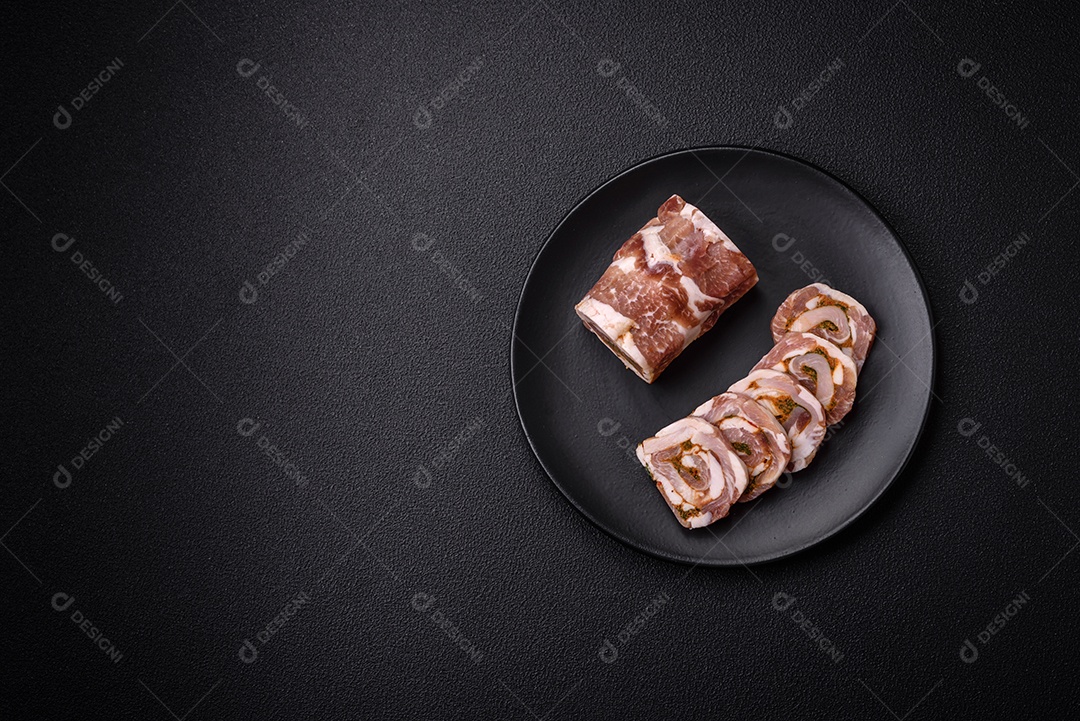 Bolo de carne delicioso com banha, sal, especiarias e ervas cortadas em fatias sobre um fundo escuro de concreto