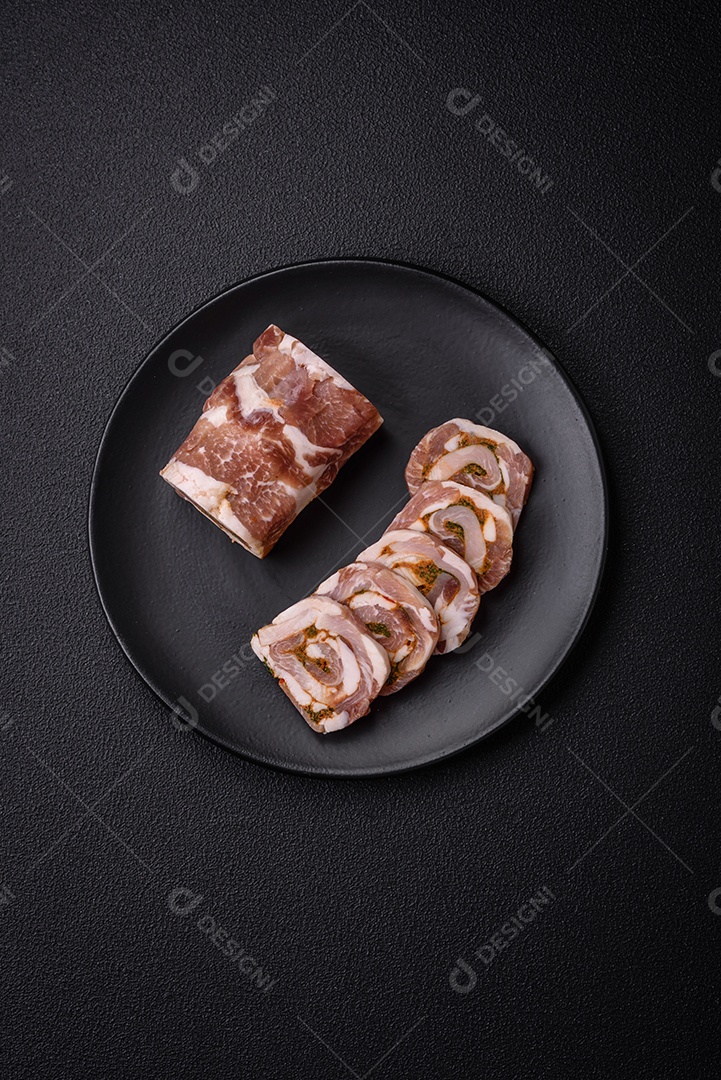 Bolo de carne delicioso com banha, sal, especiarias e ervas cortadas em fatias sobre um fundo escuro de concreto