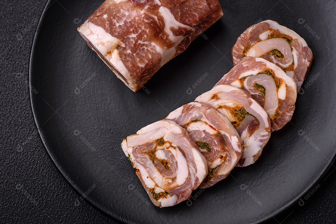 Bolo de carne delicioso com banha, sal, especiarias e ervas cortadas em fatias sobre um fundo escuro de concreto