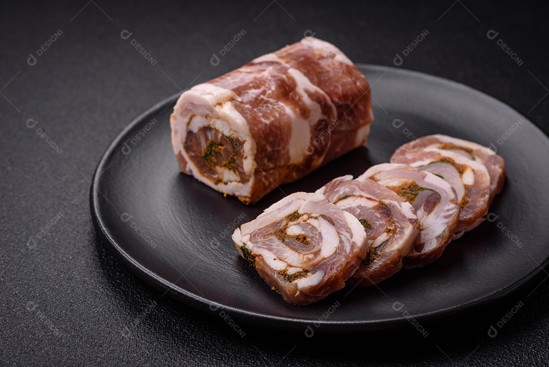 Bolo de carne delicioso com banha, sal, especiarias e ervas cortadas em fatias sobre um fundo escuro de concreto