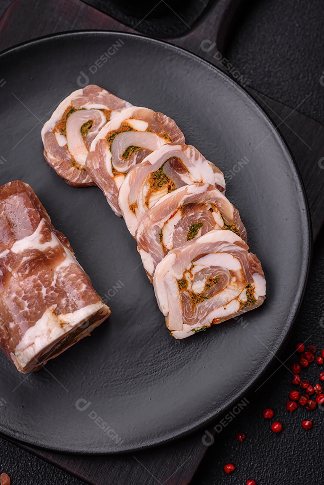 Bolo de carne delicioso com banha, sal, especiarias e ervas cortadas em fatias sobre um fundo escuro de concreto