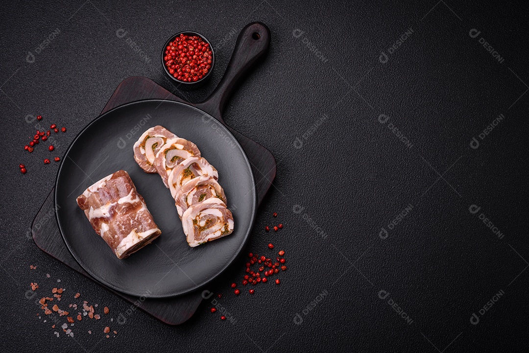 Bolo de carne delicioso com banha, sal, especiarias e ervas cortadas em fatias sobre um fundo escuro de concreto
