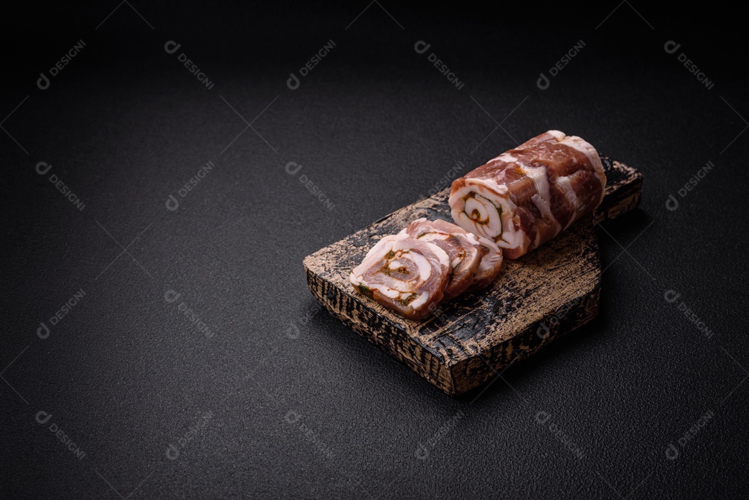 Bolo de carne delicioso com banha, sal, especiarias e ervas cortadas em fatias sobre um fundo escuro de concreto