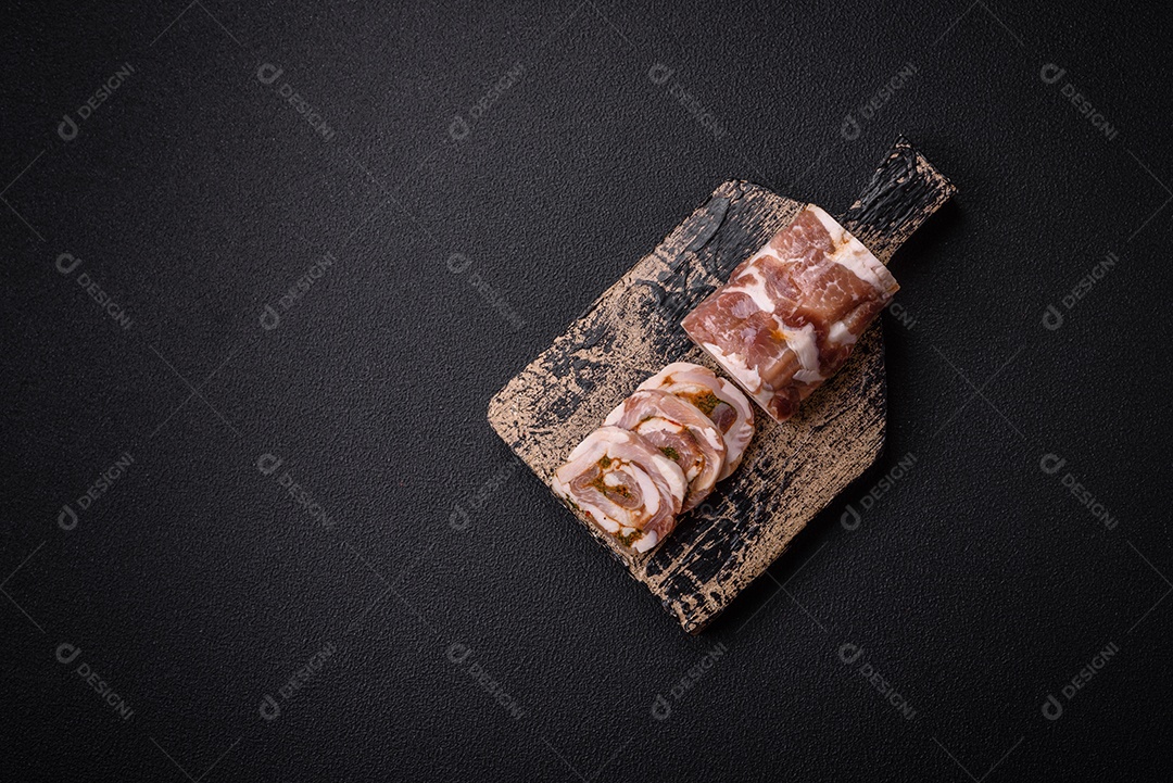 Bolo de carne delicioso com banha, sal, especiarias e ervas cortadas em fatias sobre um fundo escuro de concreto