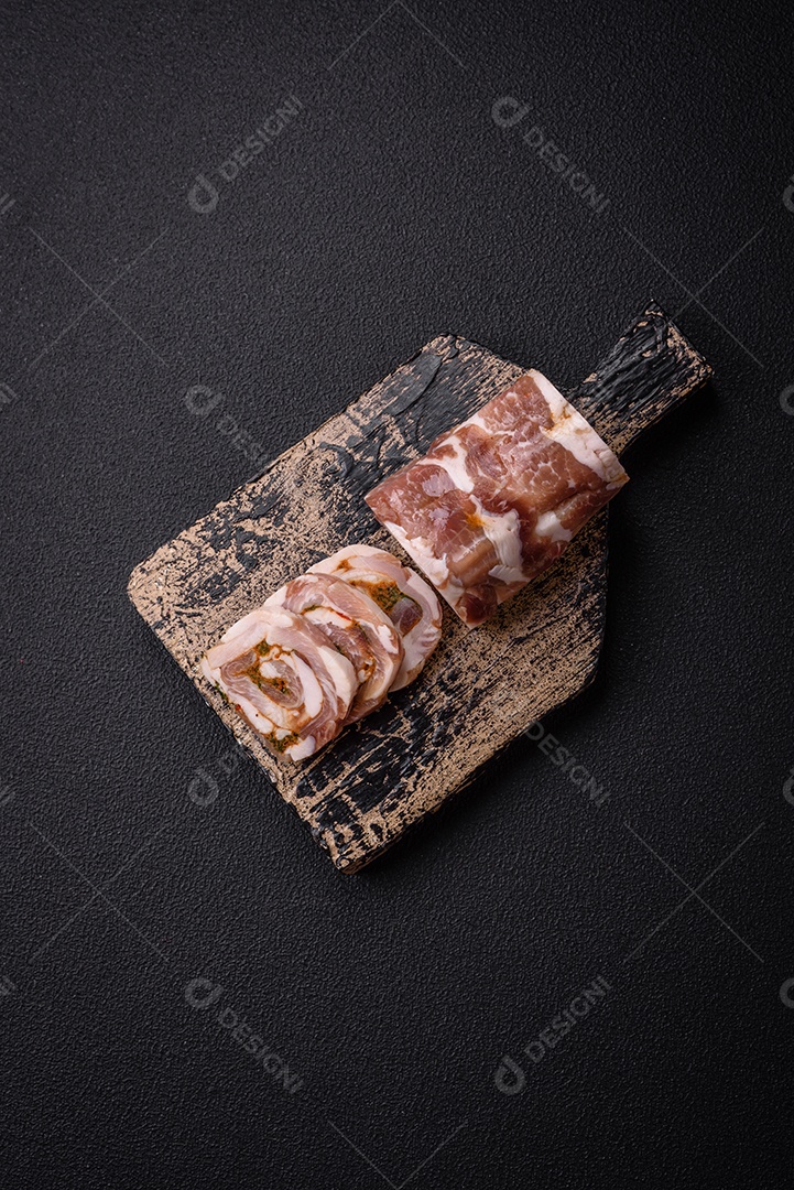 Bolo de carne delicioso com banha, sal, especiarias e ervas cortadas em fatias sobre um fundo escuro de concreto