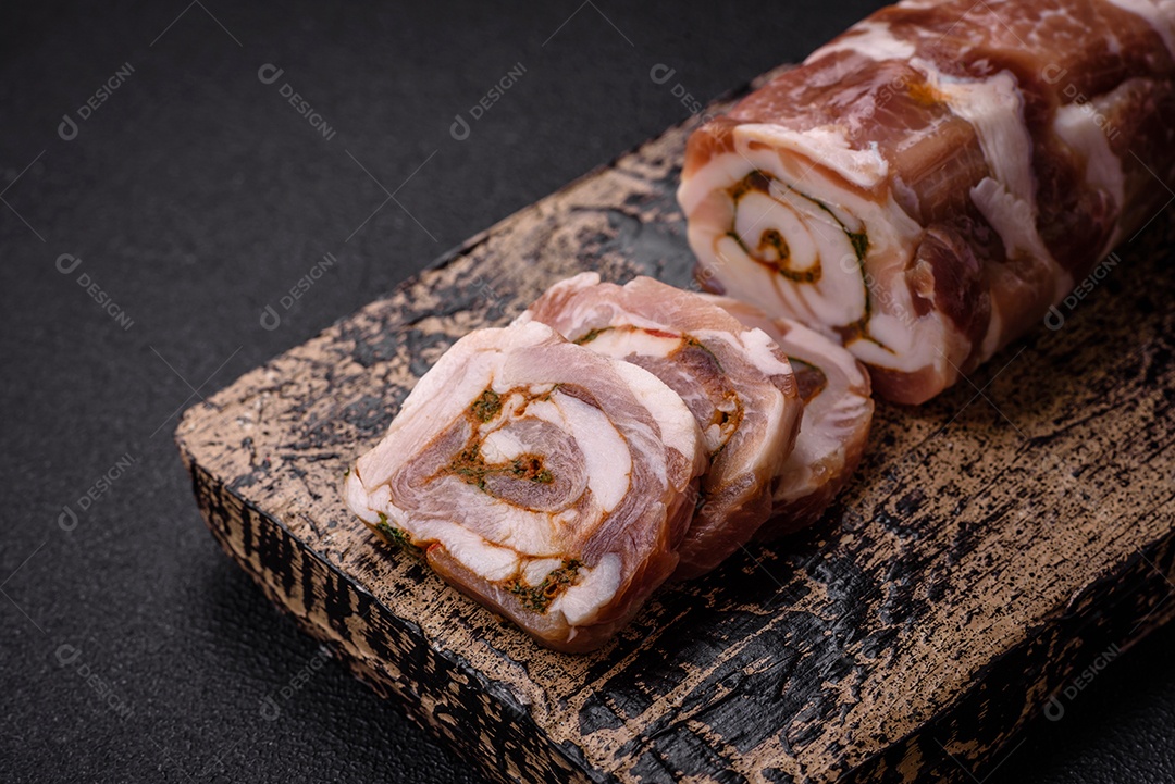 Bolo de carne delicioso com banha, sal, especiarias e ervas cortadas em fatias sobre um fundo escuro de concreto
