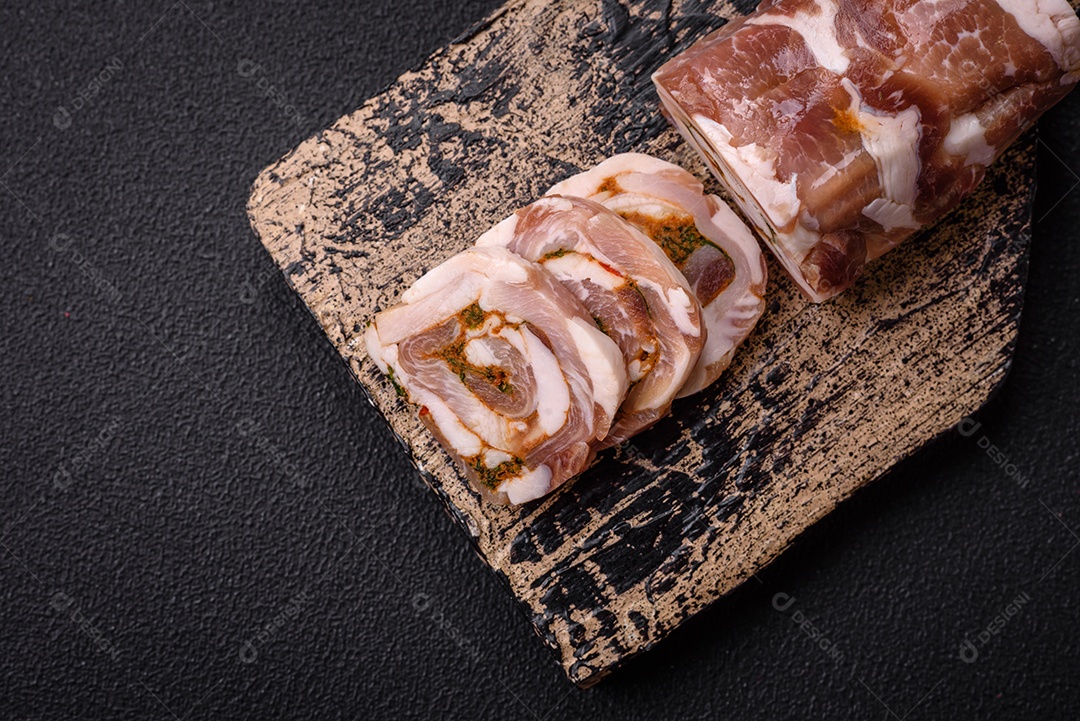 Bolo de carne delicioso com banha, sal, especiarias e ervas cortadas em fatias sobre um fundo escuro de concreto