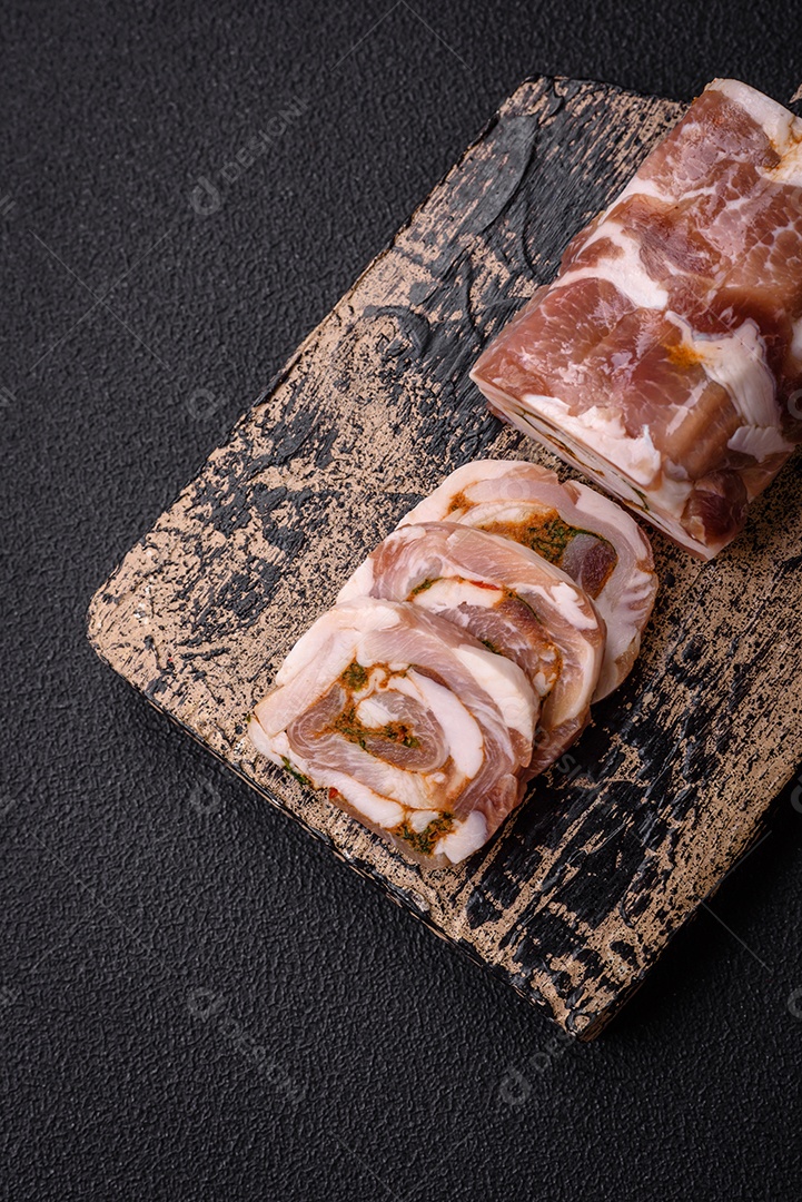 Bolo de carne delicioso com banha, sal, especiarias e ervas cortadas em fatias sobre um fundo escuro de concreto