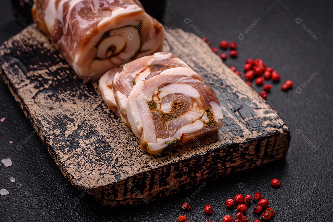 Bolo de carne delicioso com banha, sal, especiarias e ervas cortadas em fatias sobre um fundo escuro de concreto
