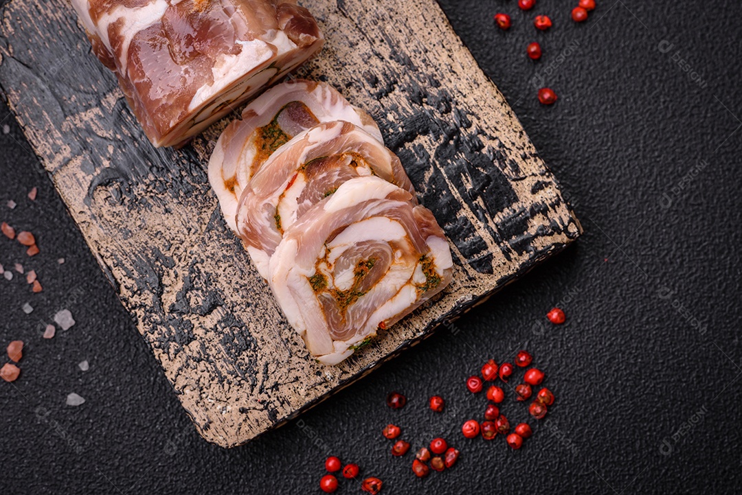 Bolo de carne delicioso com banha, sal, especiarias e ervas cortadas em fatias sobre um fundo escuro de concreto