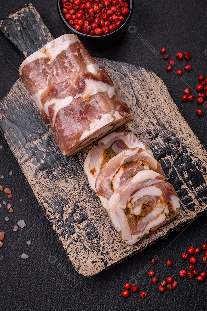 Bolo de carne delicioso com banha, sal, especiarias e ervas cortadas em fatias sobre um fundo escuro de concreto