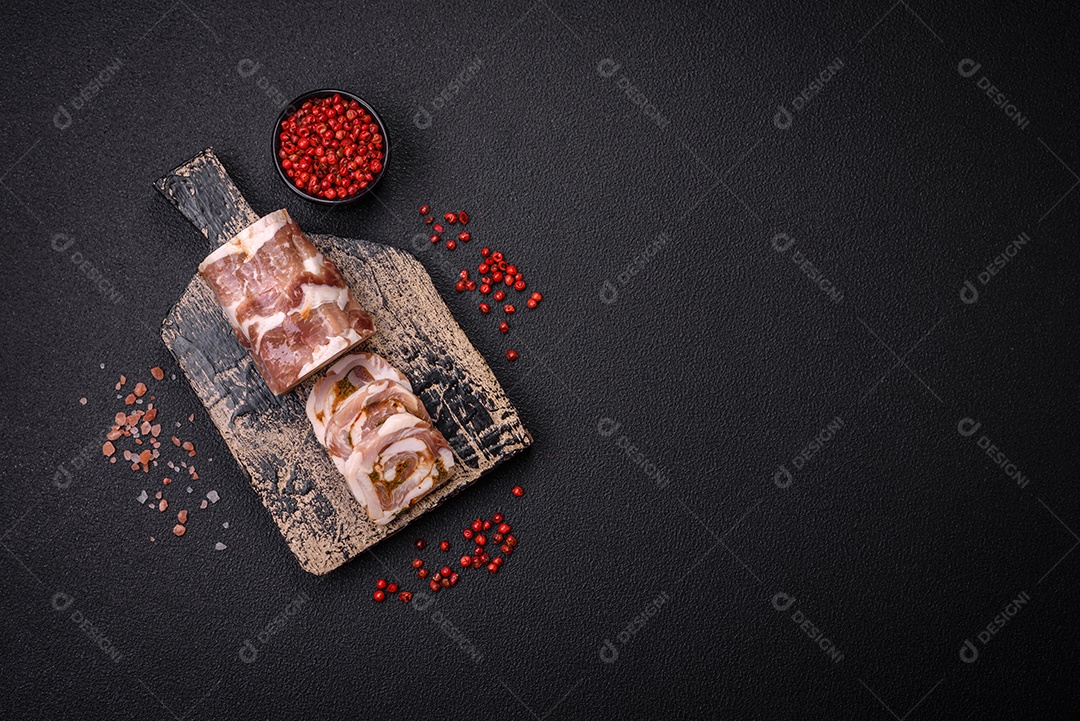 Bolo de carne delicioso com banha, sal, especiarias e ervas cortadas em fatias sobre um fundo escuro de concreto