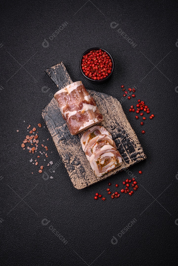 Bolo de carne delicioso com banha, sal, especiarias e ervas cortadas em fatias sobre um fundo escuro de concreto