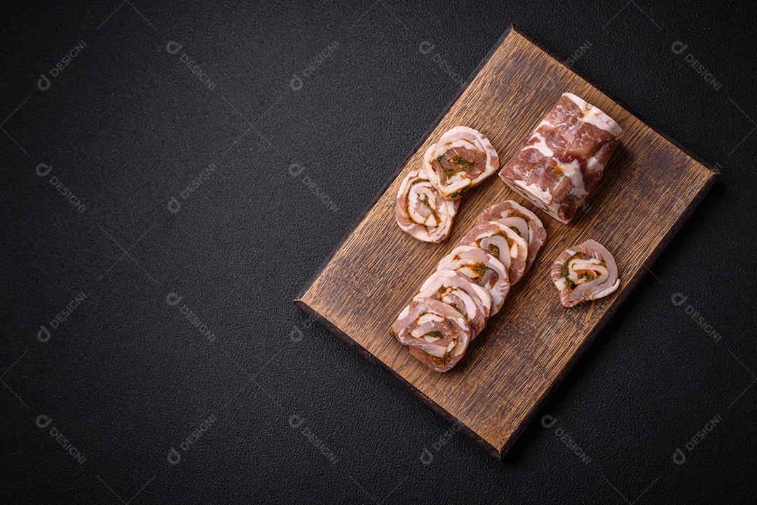 Bolo de carne delicioso com banha, sal, especiarias e ervas cortadas em fatias sobre um fundo escuro de concreto