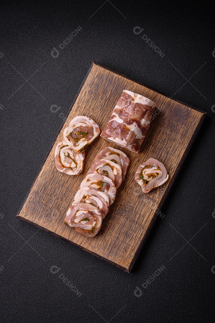 Bolo de carne delicioso com banha, sal, especiarias e ervas cortadas em fatias sobre um fundo escuro de concreto