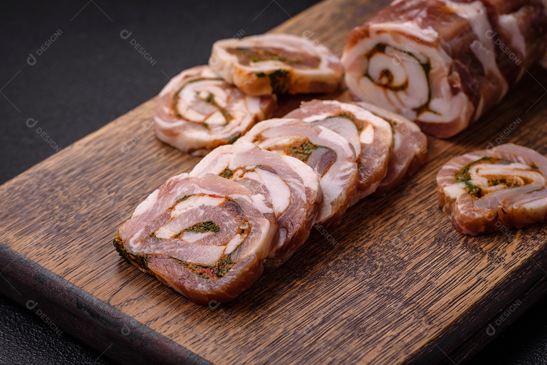Bolo de carne delicioso com banha, sal, especiarias e ervas cortadas em fatias sobre um fundo escuro de concreto