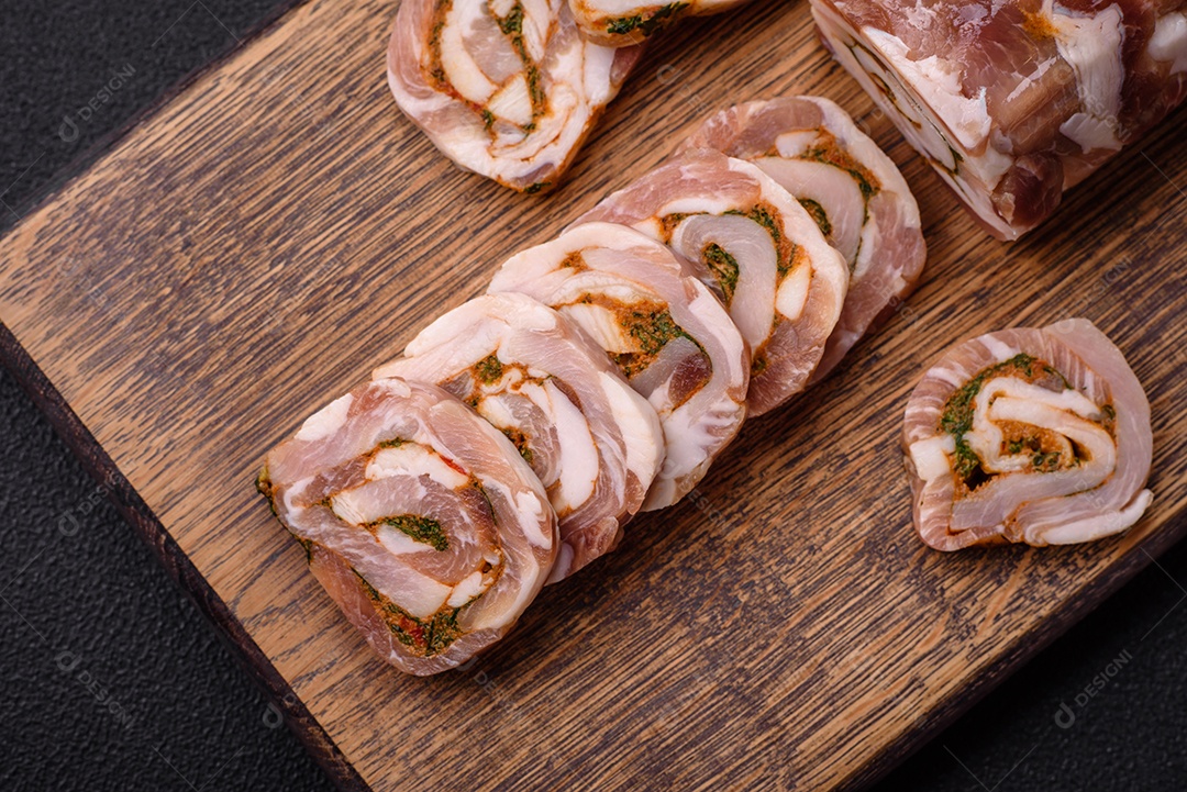 Bolo de carne delicioso com banha, sal, especiarias e ervas cortadas em fatias sobre um fundo escuro de concreto