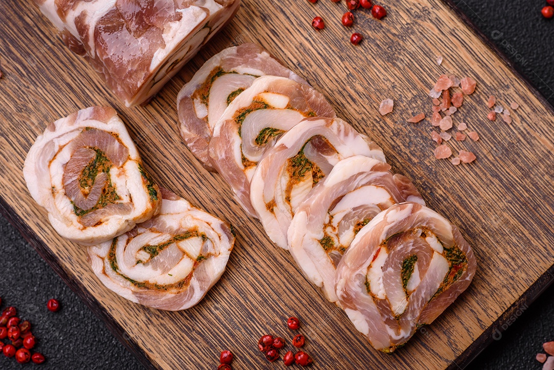Bolo de carne delicioso com banha, sal, especiarias e ervas cortadas em fatias sobre um fundo escuro de concreto