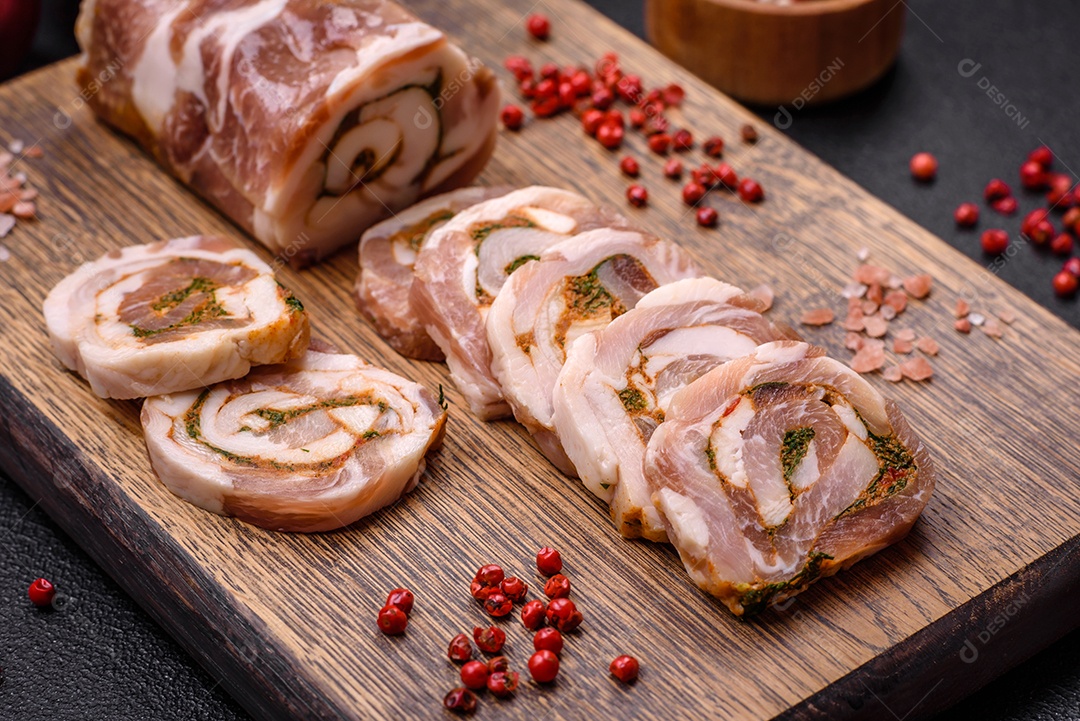 Bolo de carne delicioso com banha, sal, especiarias e ervas cortadas em fatias sobre um fundo escuro de concreto