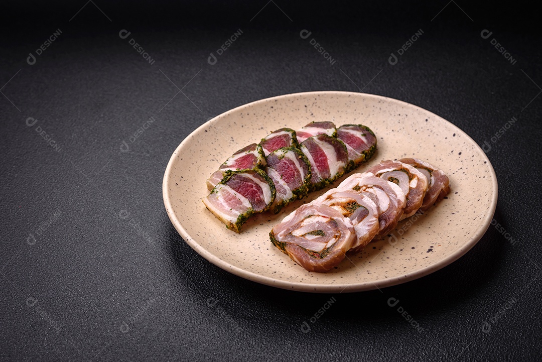 Bolo de carne delicioso com banha, sal, especiarias e ervas cortadas em fatias sobre um fundo escuro de concreto