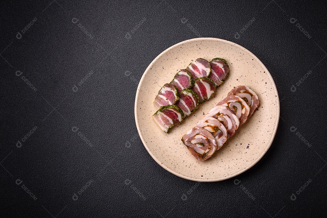 Bolo de carne delicioso com banha, sal, especiarias e ervas cortadas em fatias sobre um fundo escuro de concreto