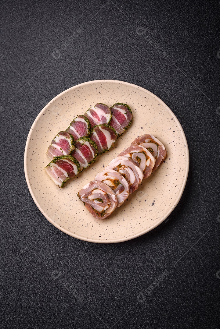 Bolo de carne delicioso com banha, sal, especiarias e ervas cortadas em fatias sobre um fundo escuro de concreto