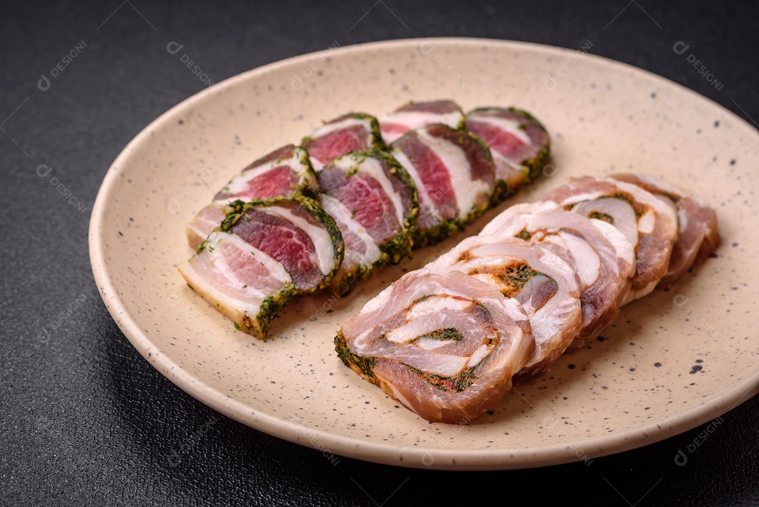Bolo de carne delicioso com banha, sal, especiarias e ervas cortadas em fatias sobre um fundo escuro de concreto