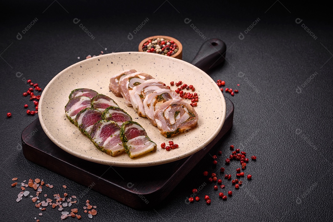 Bolo de carne delicioso com banha, sal, especiarias e ervas cortadas em fatias sobre um fundo escuro de concreto