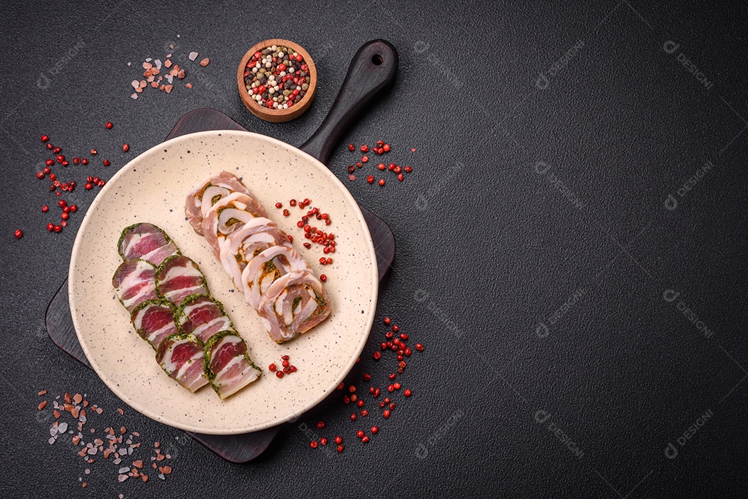 Bolo de carne delicioso com banha, sal, especiarias e ervas cortadas em fatias sobre um fundo escuro de concreto