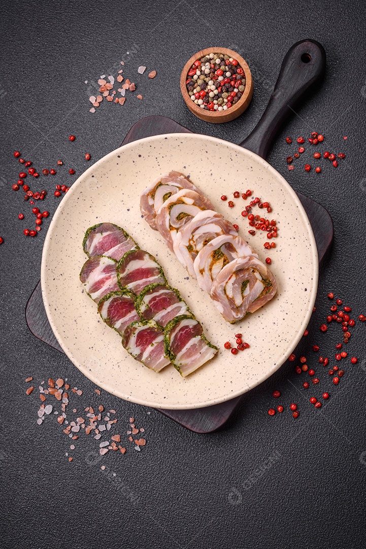 Bolo de carne delicioso com banha, sal, especiarias e ervas cortadas em fatias sobre um fundo escuro de concreto