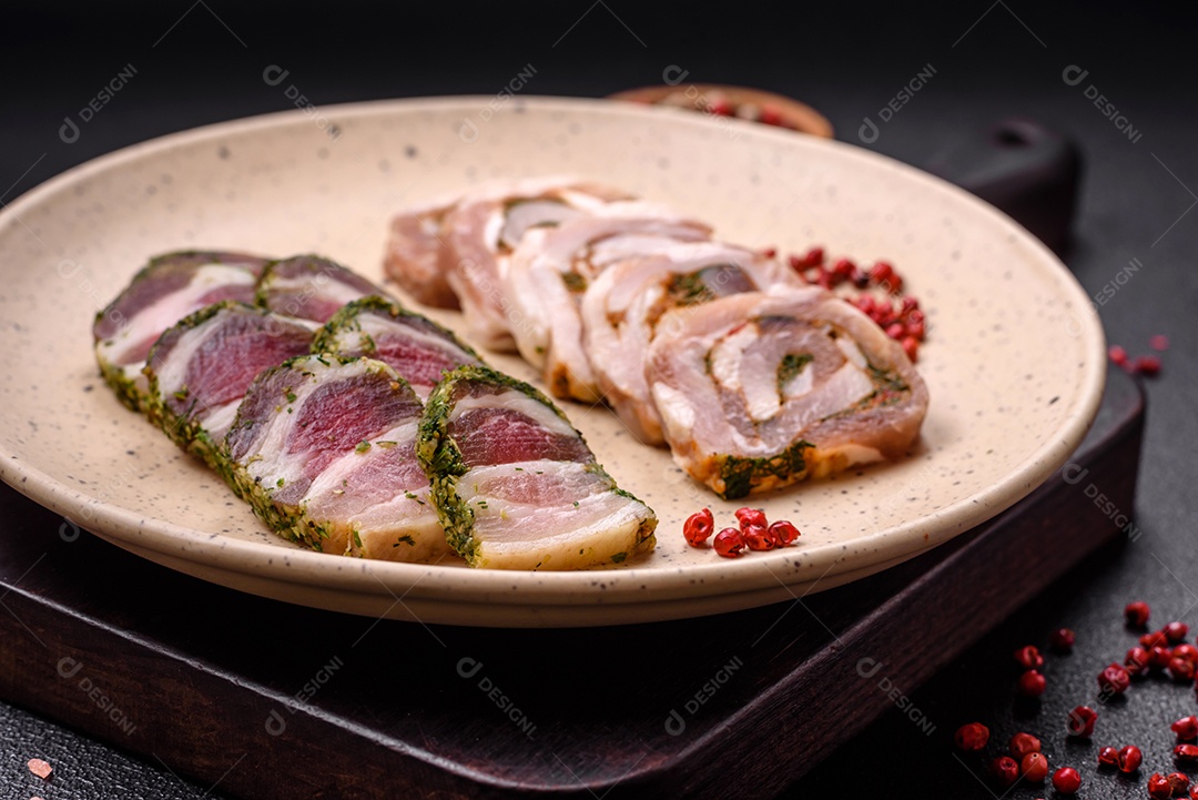 Bolo de carne delicioso com banha, sal, especiarias e ervas cortadas em fatias sobre um fundo escuro de concreto
