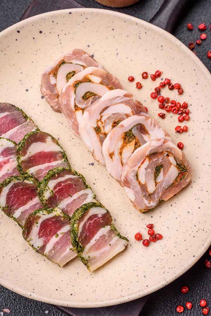 Bolo de carne delicioso com banha, sal, especiarias e ervas cortadas em fatias sobre um fundo escuro de concreto