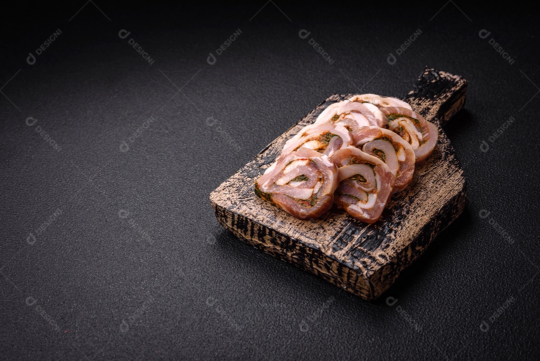 Bolo de carne delicioso com banha, sal, especiarias e ervas cortadas em fatias sobre um fundo escuro de concreto