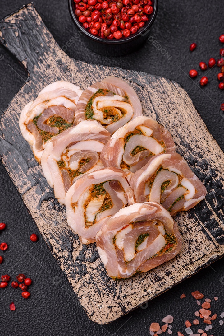 Bolo de carne delicioso com banha, sal, especiarias e ervas cortadas em fatias sobre um fundo escuro de concreto
